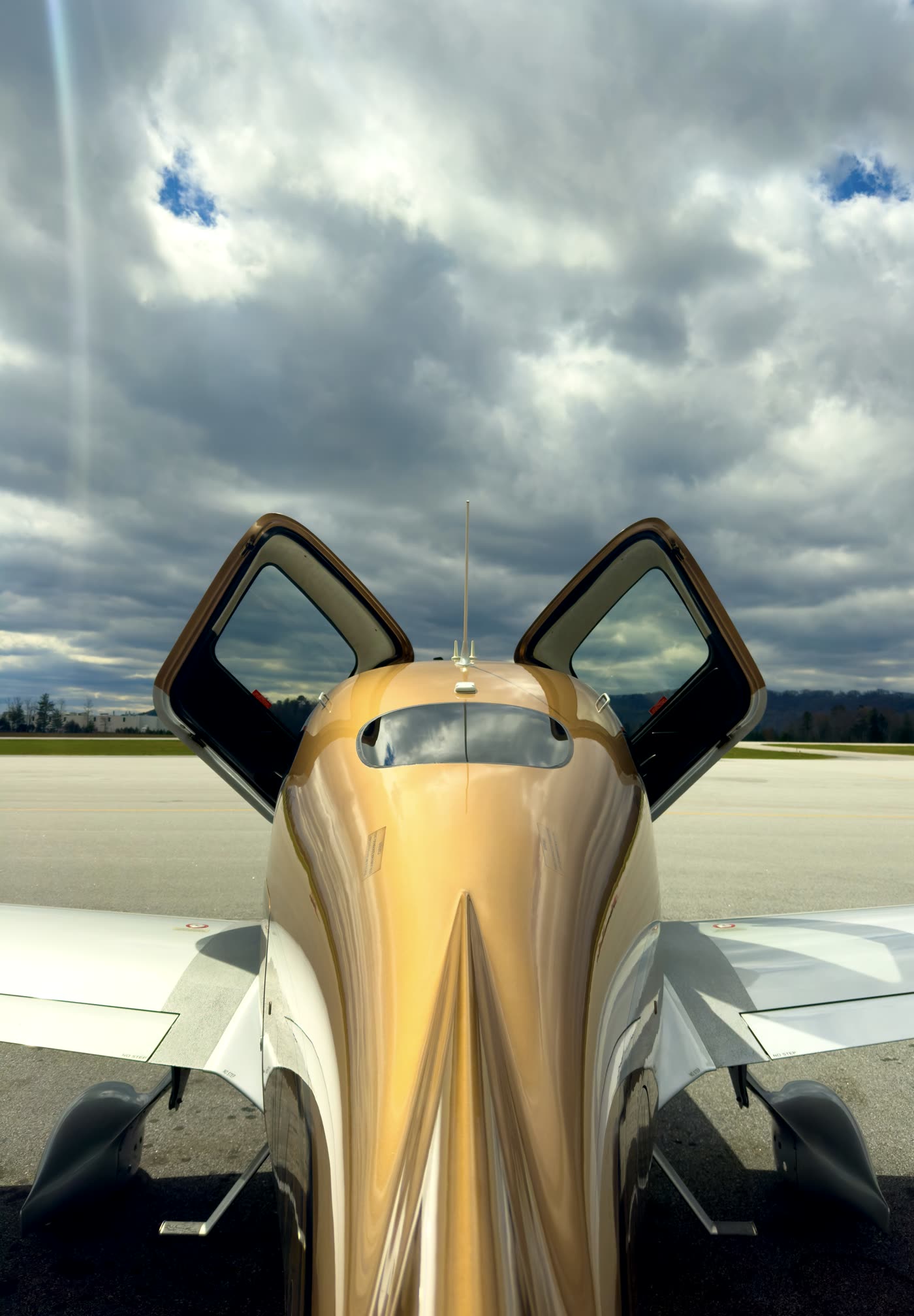 Cirrus SR with both doors open on the ramp beneath a dramatic sky