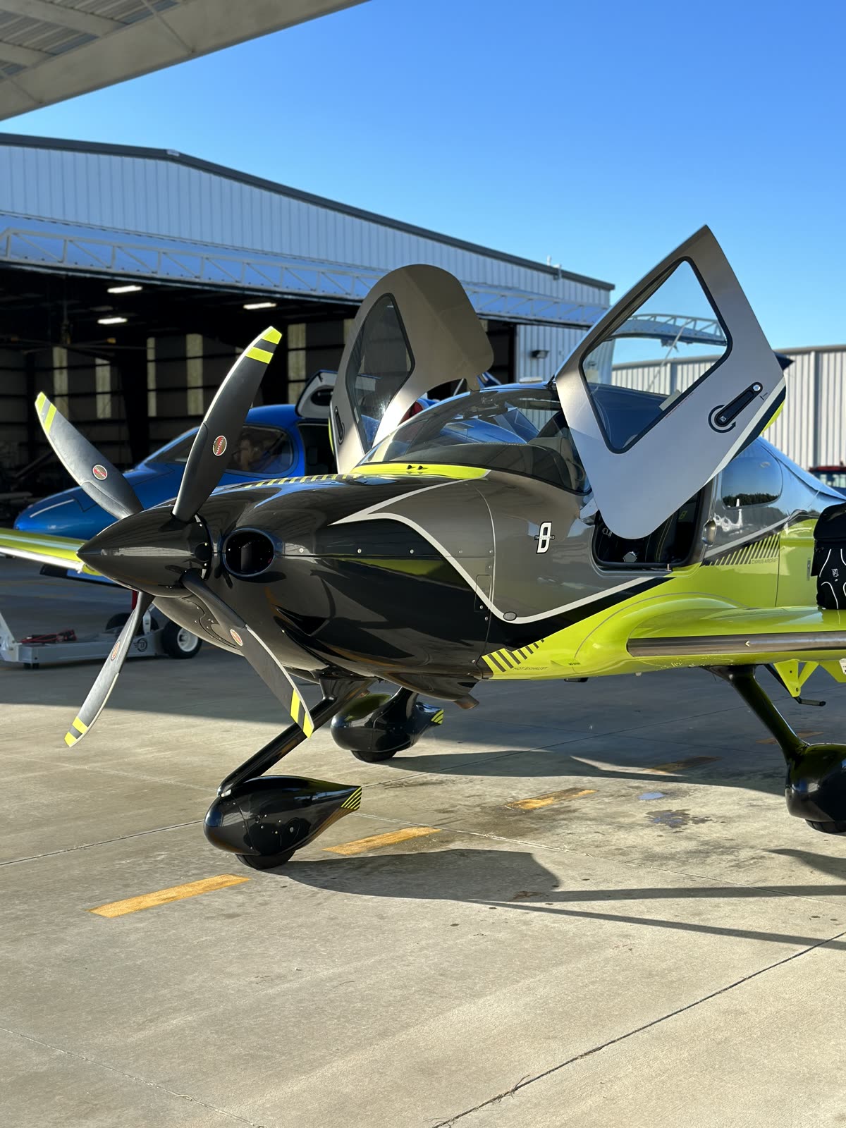 Volt green Cirrus SR in the hangar with doors open